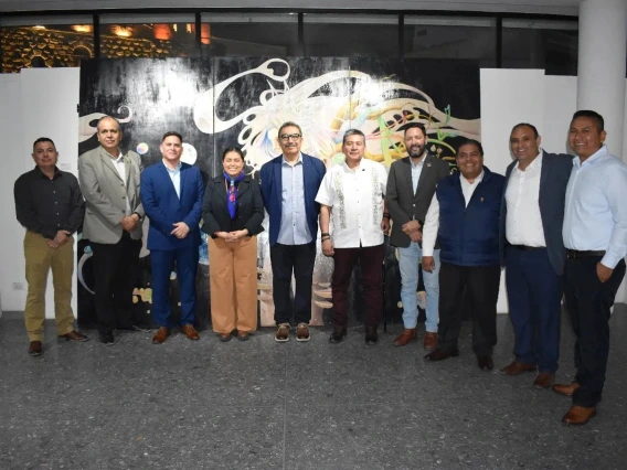 Group of people standing together in front of a art piece